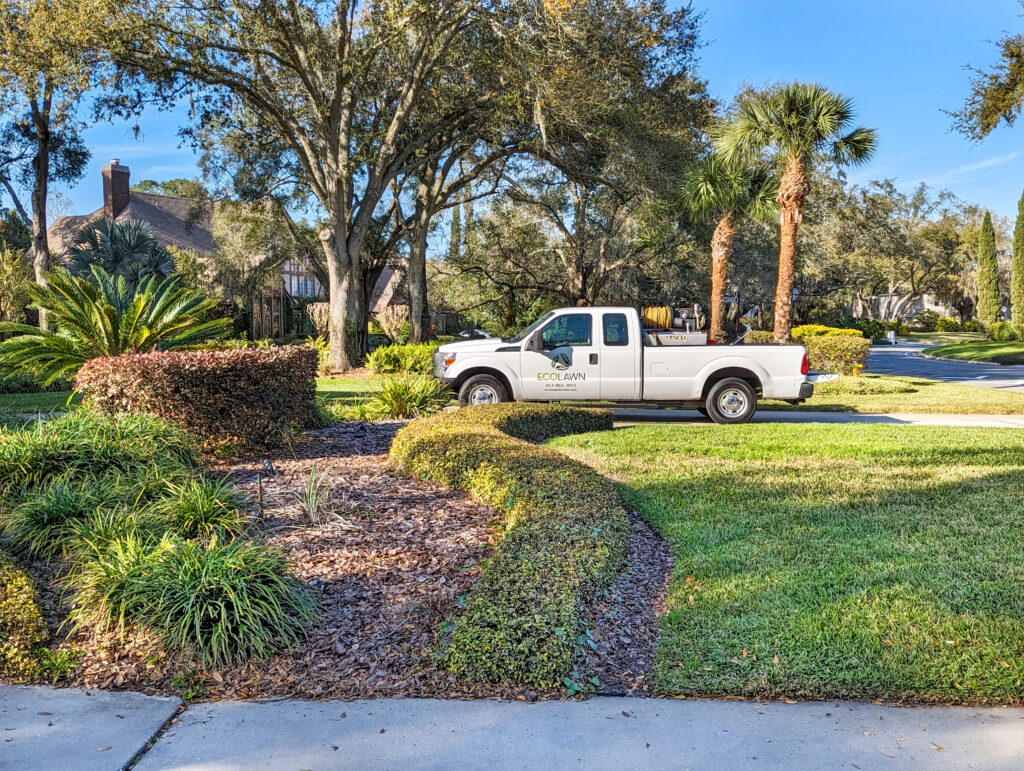 Eco lawn Truck in background while performing Flowerbed Weed Control Service